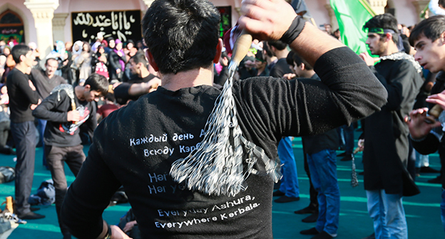 Церемония по случаю траура Ашура в Нардаране. На рубашке молодого человека, который бьет себя цепями, написано "Каждый день Ашура, каждый день Кербела". 24 октября 2015 г. Фото Азиза Каримова для "Кавказского узла"