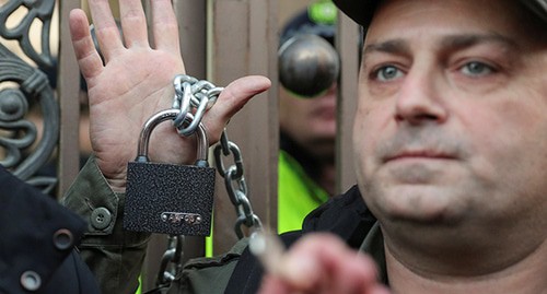 Opposition supporters chain the gate of the parliament during a rally to protest against the government and demand an early parliamentary election, in Tbilisi, Georgia November 17, 2019. REUTERS/Irakli Gedenidze