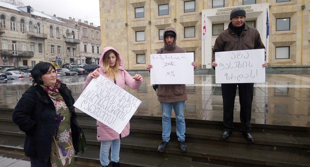 Активисты на акции. Надписи на плакатах: "Повышение цен во время пандемии -уголовное преступление". «Подоходный налог- нет 20% да 10 %» Нет подорожанию цен. Фото Беслана Кмузова для "Кавказского узла"